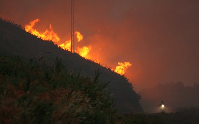 What conditions cause large wildfires in Portugal and Spain?