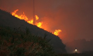 What conditions cause large wildfires in Portugal and Spain?